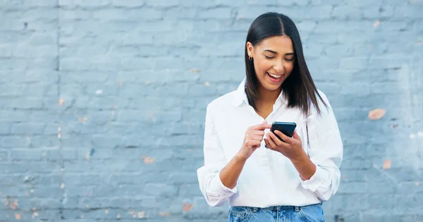 快乐的年轻女人用电话发短信 在城市里大笑 在浏览应用程序 滚动社交媒体以及在城市旅行和通勤时上网搜索时 快乐的女性面带微笑 — 图库照片