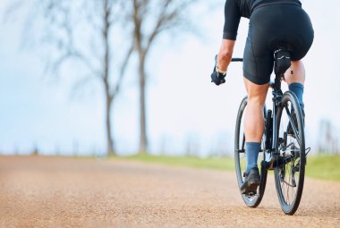 Bisiklet, açık hava ve çakıllı bir yolda spor yarışları için bisikletle gezen biri. Spor, egzersiz ve spor yapan hızlı bir sporcu. Kardiyo ve egzersiz için park yolunda spor yapıyor..