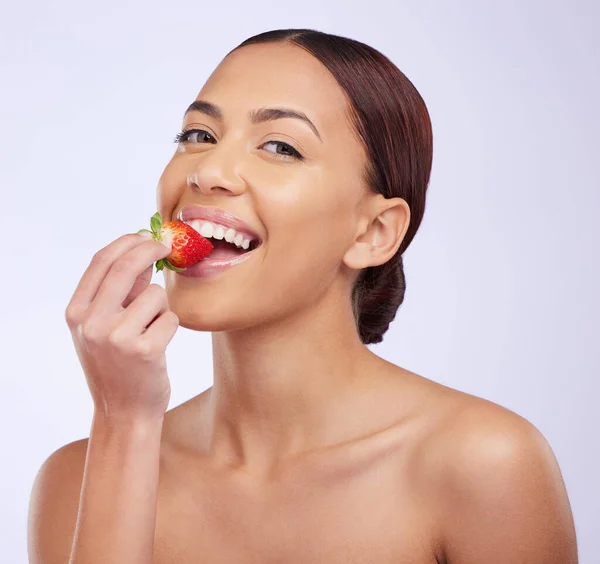 stock image Woman, skincare and studio portrait with strawberry for self care, diet or beauty with benefits for glow on face. Girl, model and fruit for eating with wellness, health and dermatology by background.