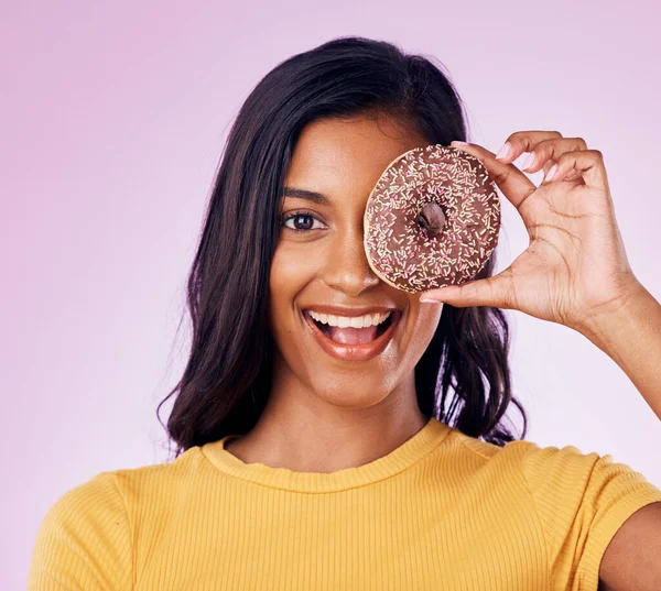 stock image Donut, cover with portrait of woman in studio for diet, snack and happiness. Sugar, food and smile with female hiding and isolated on pink background for nutrition, playful and craving mockup.