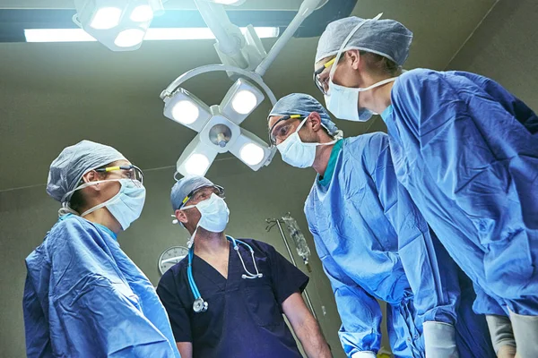 Ameliyathanede Birbirlerini Kolluyorlar Ameliyathanede Cerrahların Düşük Açılı Görüntüsü — Stok fotoğraf