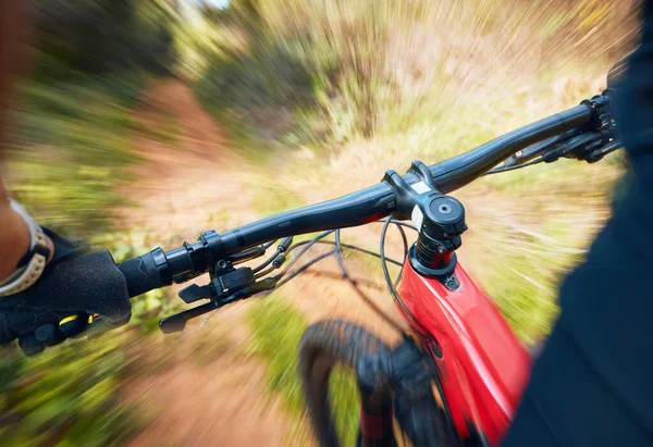 Bike, cycling and motion blur with a sports person holding handle bars while riding outdoor closeup pov. Bicycle, fitness and speed with a cyclist or athlete mountain biking in nature during summer.