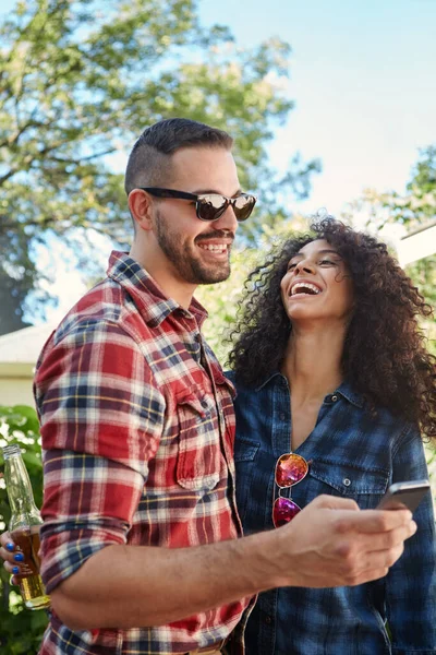 stock image Thats hilarious. a young man sharing something on his cellphone with his girlfriend