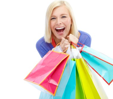 Alışveriş için çok heyecanlıyım. Beyaz bir arka planda izole edilmiş alışveriş torbaları taşıyan heyecanlı bir genç kadın.