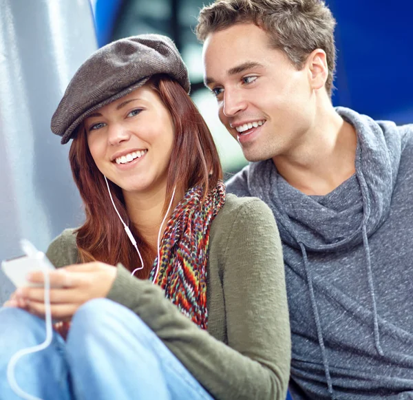 stock image The girl of my dreams. a pretty girl listening to music on her phone while her boyfriend looks at her lovingly