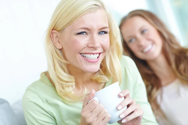 おいしいコーヒーと偉大な会社 二人の魅力的な若い女性が一緒にコーヒーを飲みながら笑う — ストック写真