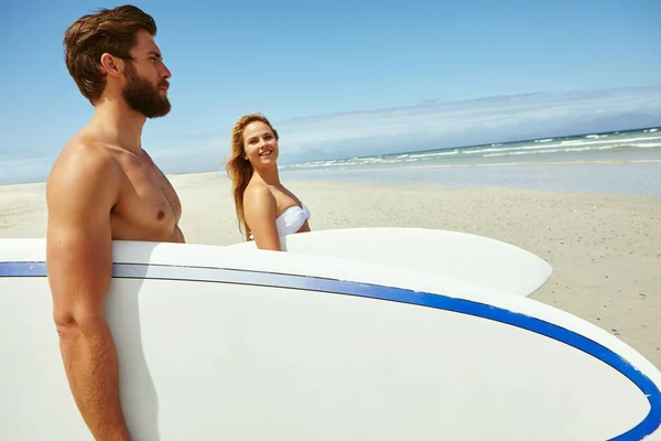 彼らはサーフィンやお互いを十分に得ることはできません ビーチを歩いている若いカップルがサーフボードを持っていて — ストック写真