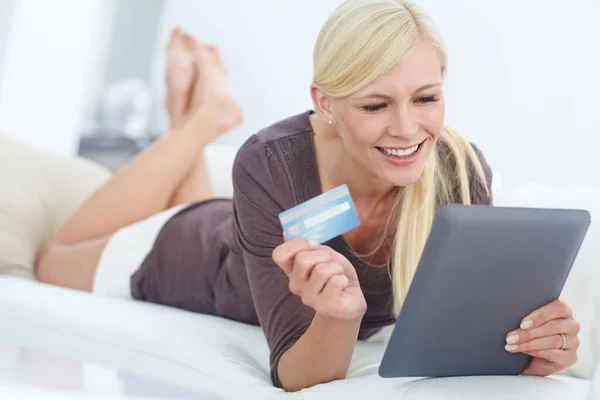 彼女はクレジットカードを用意した 美しい女性がデジタルタブレットを使って自宅でオンラインショッピングをしています — ストック写真