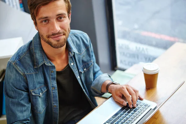 仕事に行く時間だがまずコーヒーだ コーヒーショップでノートパソコンを使用してハンサムな若い男の肖像画 — ストック写真
