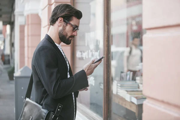 stock image Sending a quick text. a stylish young man using a cellphone while out in the city