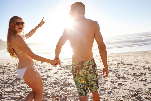 私たちは太陽と波のために生きています ビーチで午後遅くの太陽を楽しんでいる若いカップルは — ストック写真