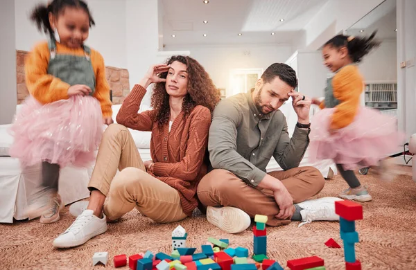 Family, girl playing and parents with stress, frustrated or in living room with a headache or burnout. Mother, father or female child with toys, busy or fast speed in lounge, home or hyper active kid.