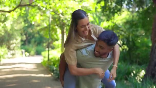 自然和小猪回来的跨种族夫妇在花园散步 并在夏天的周末结合在一起 男人带着快乐的女人笑着 在公园里谈情说爱 — 图库视频影像