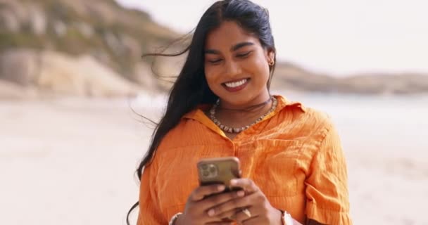 在海滩上边看书边发短信边笑 以促进网络交流 快乐和户外社交媒体 有影响力的 快乐的印度女孩 以及在网上 博客或应用程序上谈论夏天的海洋探险 — 图库视频影像