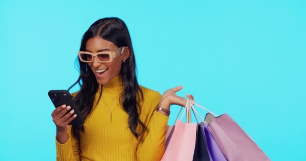 Mutlu Kadın Telefon Alışveriş Torbaları Stüdyoda Mavi Arka Planda Satılık — Stok video