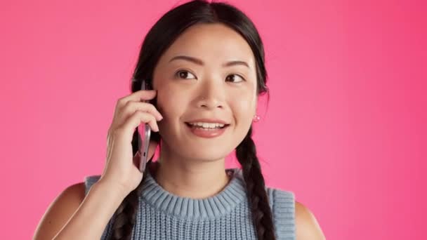 アジアの女性 顔や電話は ネットワーク 通信や連絡先のためのピンクの背景にスタジオで隔離呼び出します 幸せなまたはモバイル技術 ストーリーテリングやチャットアプリについて話す学生 — ストック動画