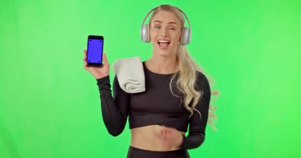 健身和手机与音乐在绿色屏幕上跳舞与耳机 微笑和网站 快乐的运动员跳舞锻炼身体 听音乐 指着智能手机 — 图库视频影像