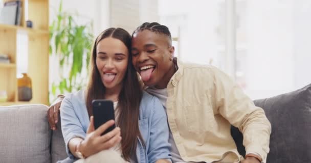 和平标志 自拍和夫妻在家里接吻 沙发和拍照 以获得美好的回忆 滑稽的 跨种族的和黑人的男人和女人伸出舌头 亲吻脸颊和在社交媒体上的表情 — 图库视频影像