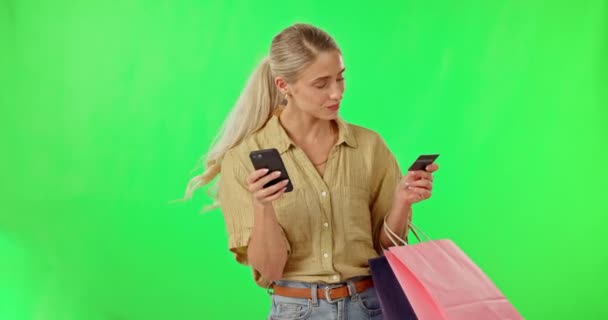 スタジオの背景にクレジットカードで緑の画面上の幸せな女性 電話やショッピングバッグ モックアップで購入 オンラインショッピングや電子商取引のためのギフトバッグとスマートフォン上の女性の肖像画 — ストック動画
