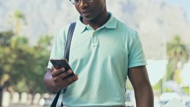 ビデオ通話 黒人男性と街の通りを歩くと 幸せと笑顔の都市の背景に通勤に 屋外で会議や交渉のためのオンライン会議での答え スマートフォンやアフリカのビジネスマン — ストック動画
