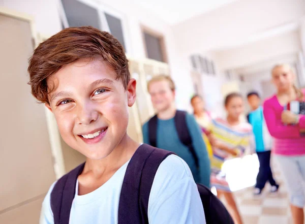 私たちの未来 バックグラウンドでクラスメートとホールに立っている若い男の子のクローズアップ肖像 — ストック写真