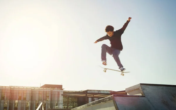 天空充满了信心 一个年轻人在滑板上玩滑板把戏的全景镜头 — 图库照片