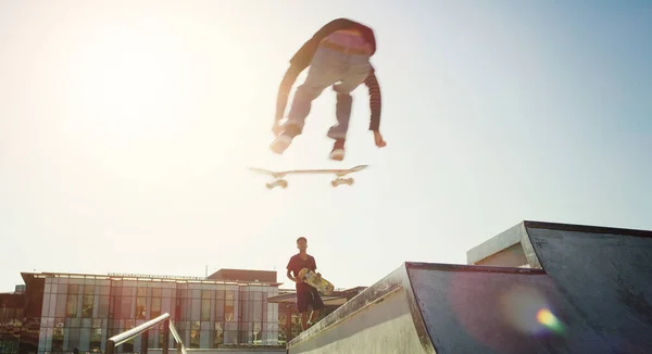 谁说人不能飞的 一个年轻人在滑板上玩滑板把戏的全景镜头 — 图库照片