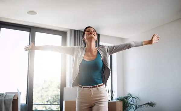 stock image So much more room to grow. an attractive young woman standing with her arms outstretched while moving into a new house