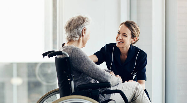 Shes all the care you need. a female nurse caring for a senior woman in a wheelchair