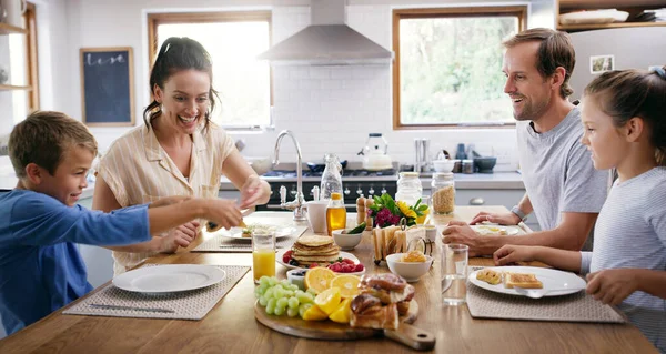 和家人一起吃饭更有趣 两个充满爱心的年轻父母在家里的厨房里和孩子们一起吃早餐 — 图库照片