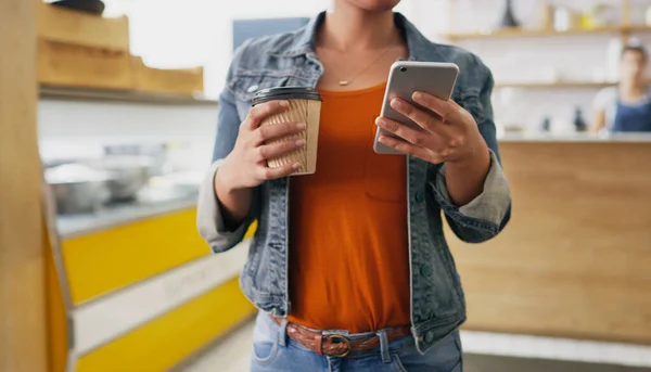 拿了杯咖啡和她的关系一起去一个无法辨认的女人在咖啡店里拿着一杯咖啡时 用手机拍了一张合影 — 图库照片