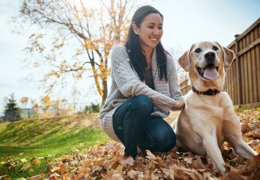 Doğrudan kalbime pençe izleri bırakıyor. Çekici bir genç kadın bir sonbahar günü bahçede köpeğiyle eğleniyor.