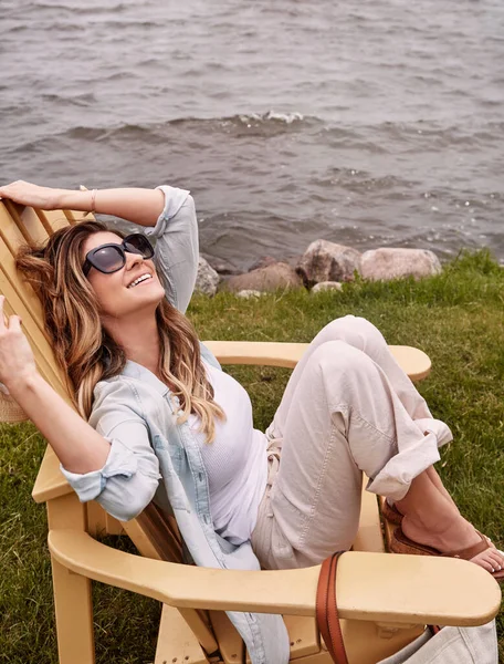 最好的日子是无所事事 一位年轻貌美的女子坐在湖边的椅子上休息 — 图库照片