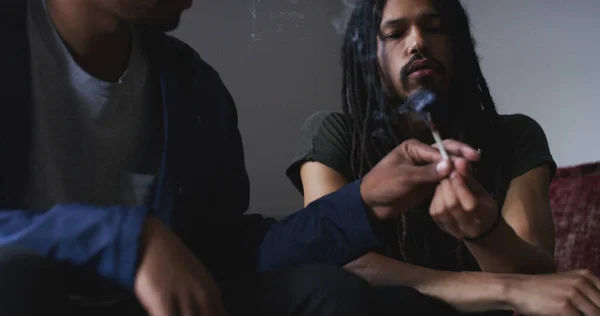 stock image What they get up on the weekends. two young men smoking a marijuana joint at home