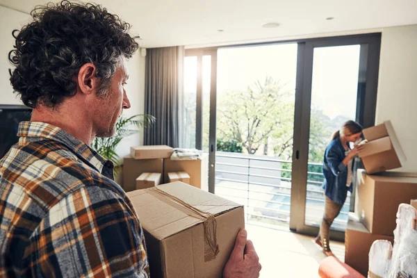 stock image Where can it be. a focused middle aged couple packing out a boxes at their new home inside during the day