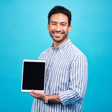 Adam, tablet ve maket ekran, portre ve dijital cihaz pazarlamasında gülümse mavi arka planda teknolojiyle birlikte. Kablosuz dokunmatik ekran, web sitesi veya internet markası, reklam ve mutlu erkek stüdyoda.