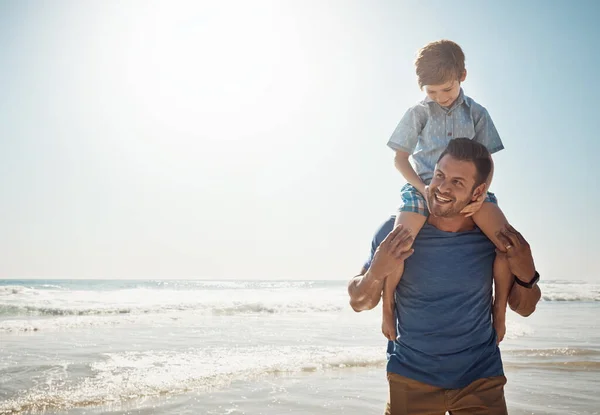 二人が一緒にいると日が明るくなる ビーチで息子を肩に担いでいた父親が — ストック写真