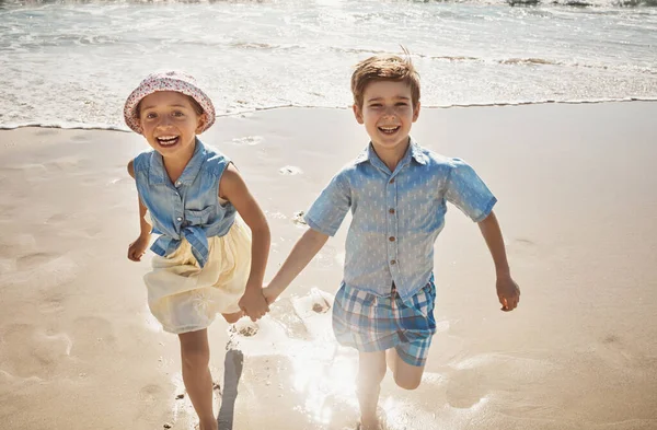 とてもビーチにいることに興奮していた ビーチで手をつないで走る2人の愛らしい子供たち — ストック写真