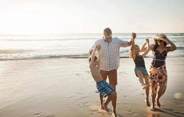 彼らの顔はビーチで喜びに照らされています ビーチで一日を過ごす4人家族が — ストック写真