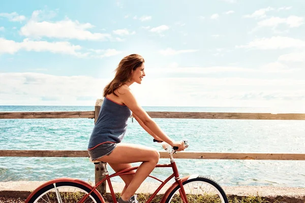 健康是一种生活方式 一个漂亮的年轻女子骑着自行车走在人行道上 — 图库照片
