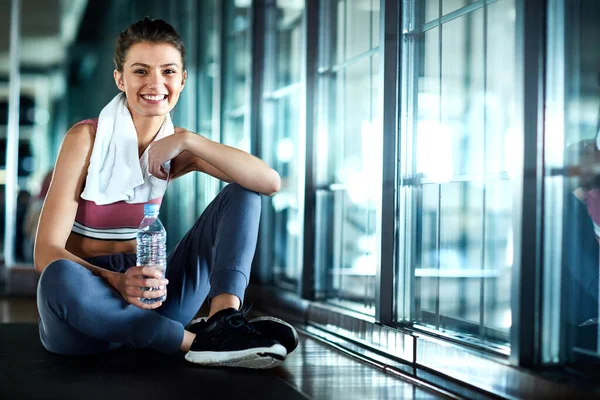 stock image Exercise is the only hobby I need. an attractive young woman taking a break during her workout in the gym