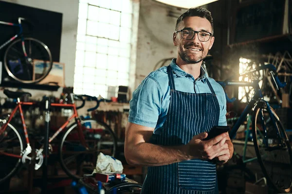 stock image Im the guy to call to get your bike fixed. Portrait of a mature man working in a bicycle repair shop