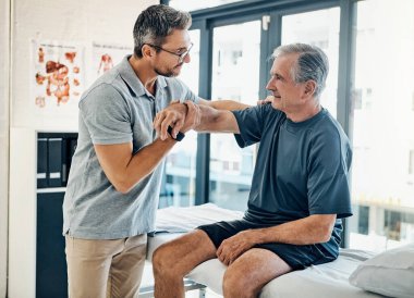 Hareket kabiliyetin gelişmeye devam ediyor. Yetenekli bir fizyoterapist, yetişkin hastalarının rehabilitasyon merkezinde hareket kabiliyetlerini test ediyor.