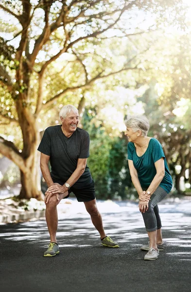 Prolonging good health through fitness. a senior couple warming up before a run outside