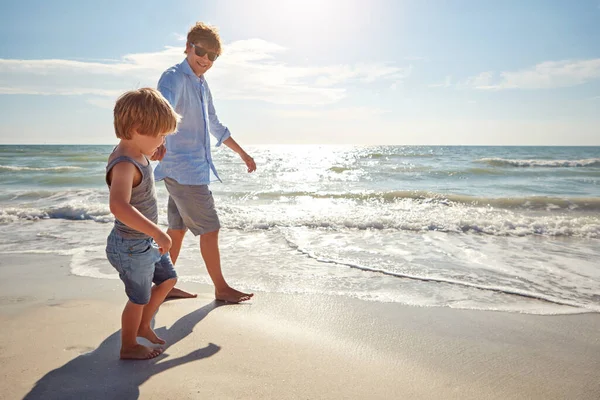 彼の父親の足跡を歩く 若い男と息子がビーチで夏の日を楽しんで — ストック写真