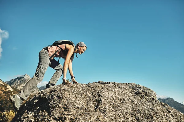 征服伟大的户外 一个年轻女子在爬山时爬过岩石 — 图库照片