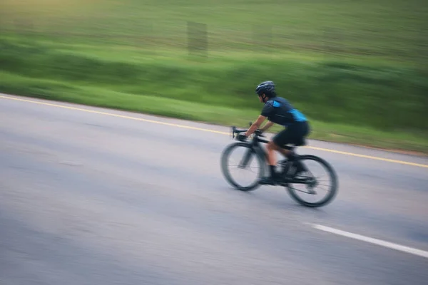 在训练 三项全能和运动能力方面 骑自行车和骑自行车的速度在农村地区的室外运动模糊了人们对自行车的认识 自行车和马拉松赛在模拟道路上的健康 精力和表现 — 图库照片