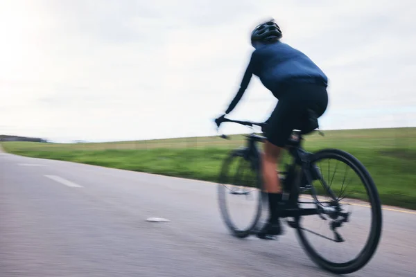自行车和自行车在运动上的模糊 天空的模型和乡村道路为铁人三项全能运动员从后面 自行车 自行车和速度慢 用于运动训练 有氧运动和竞赛能力 — 图库照片
