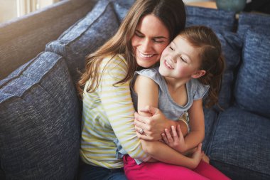 Hiçbir şey annelerin koşulsuz sevgisinden daha doğru değildir. Bir anne ve kızı evde kaynaşıyor.