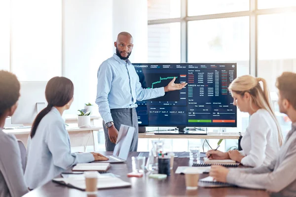 Stock image Black man, trading coach and screen with stock market dashboard, meeting with business people and trader training. Cryptocurrency, finance with stocks information and presentation in conference room.